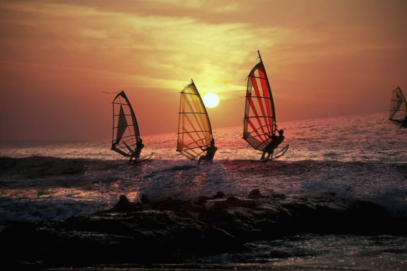 Surfen bei Sonnenuntergang in Terifa, Spanien © iStock.com/ManuelVelasco
