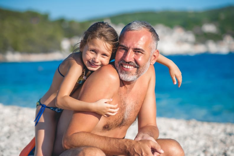 Vater mit seiner Tochter beim Strandurlaub ©CasarsaGuru/iStock