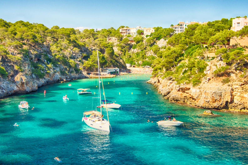 blaues Meer in einer Bucht von Mallorca mit einigen Booten © iStock.com/Josep Bernat Sànchez Moner