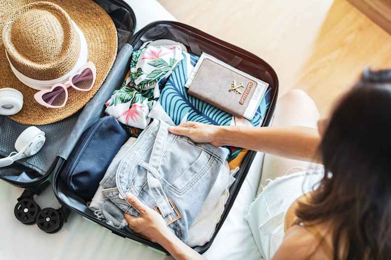 Eine Frau packt einen Koffer.