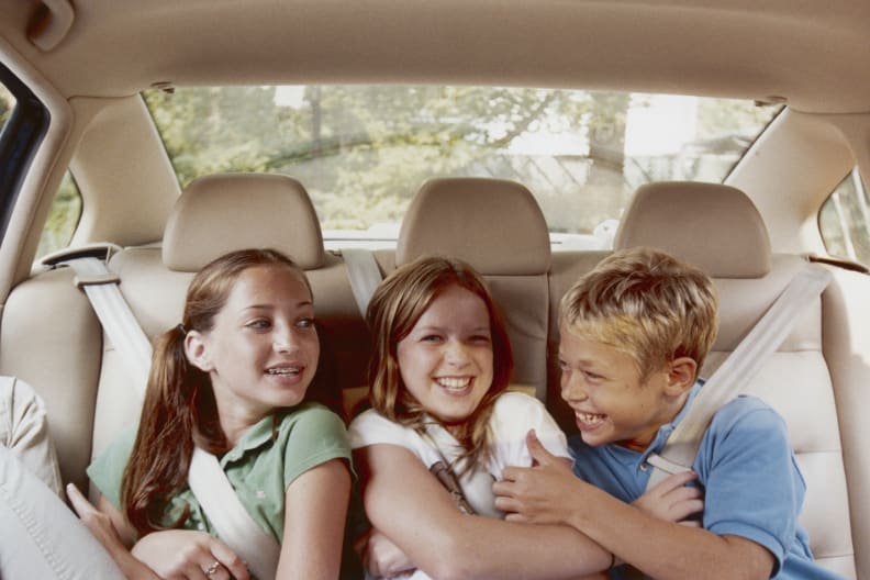 Drei Kinder auf der Rückbank eines Autos. © Sean De Burca/The Image Bank via Getty Images