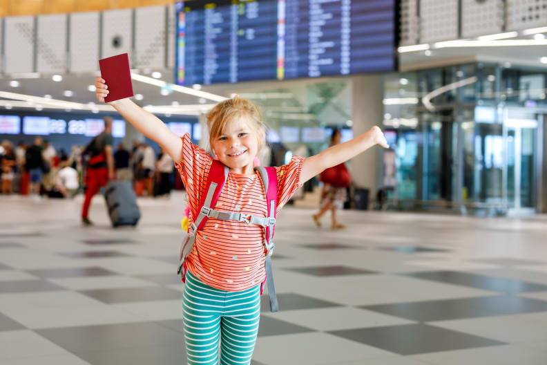 Ein kleines Mädchen mit ihrem Reisepass am Flughafen. © romrodinka/iStock / Getty Images Plus via Getty Images