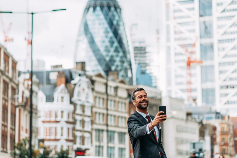 Ein Mann in Anzug macht ein Selfie in London.