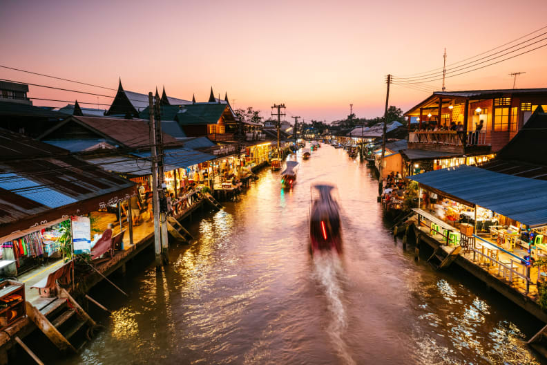 Ein schwimmender Markt in Bangkok, Thailand, im Sonnenuntergang.
