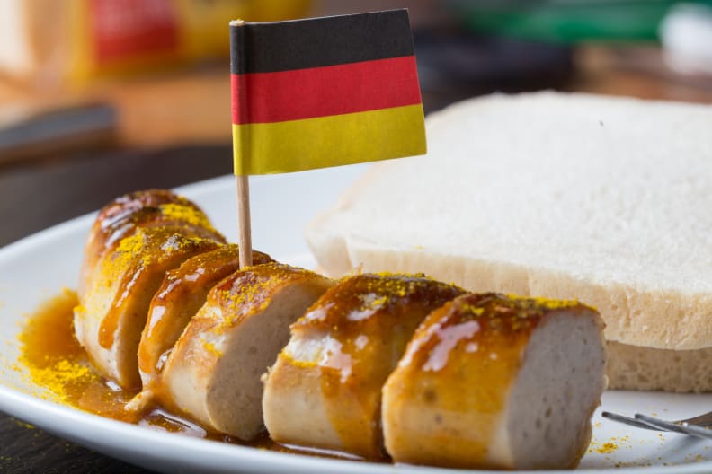 Eine Currywurst mit einer deutschen Flagge. © Teka77/iStock / Getty Images Plus via Getty Images