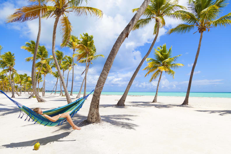 Eine Frau entspannt in einer Hängematte an einem Strand in der Dominikanischen Republik.