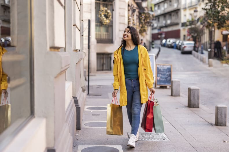 Eine glückliche junge Frau mit Einkaufstüten.