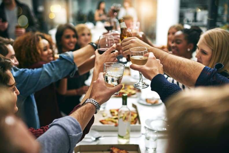 Eine Gruppe von Menschen stößt in einem Restaurant an.