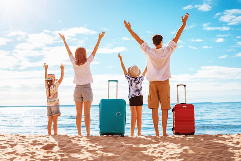 Erwachsene mit Kindern an einem Strand