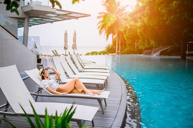 Frau in einem Liegestuhl am Pool