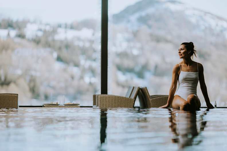 Eine Frau sitzt am Rand eines Pools
