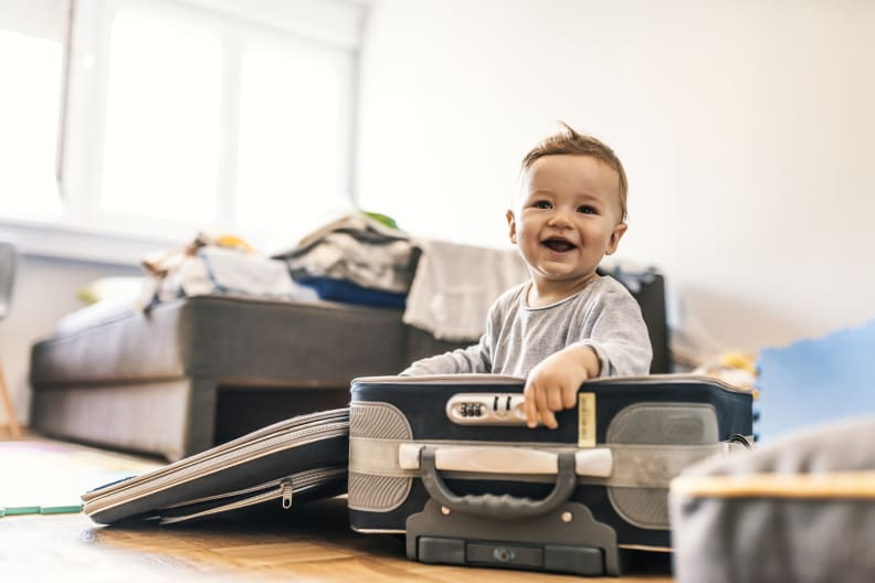 fröhliches Baby in einem Koffer © ljubaphoto/E+ via Getty Images
