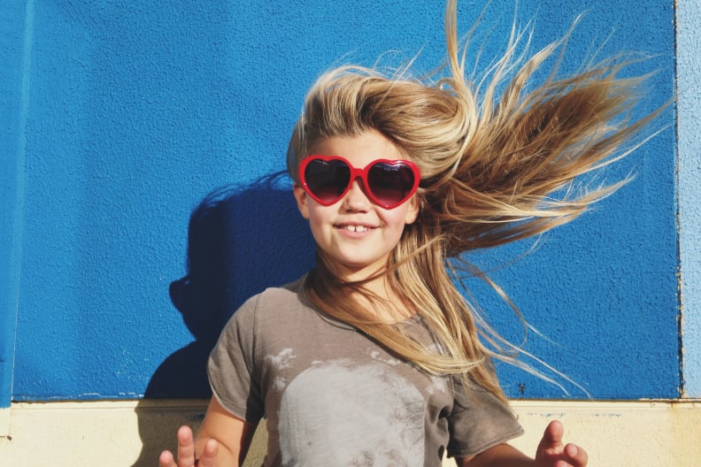 Glückliches Mädchen mit Herzen-Sonnenbrille. © Jodie Griggs/The Image Bank via Getty Images