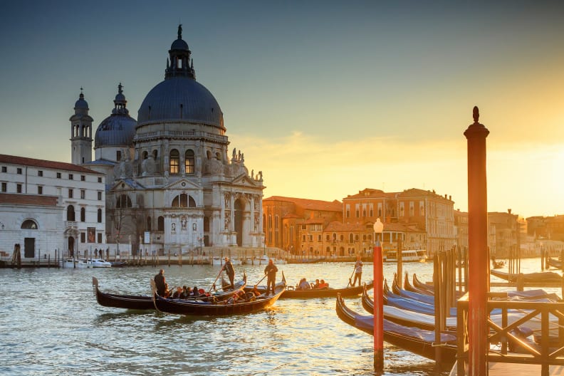 Gondeln und Wassertaxis am Canale Grande und der Kirche Santa Maria della Salute bei Sonnenuntergang, Canal Grande, Santa Maria della Salute, Venedig, Italien