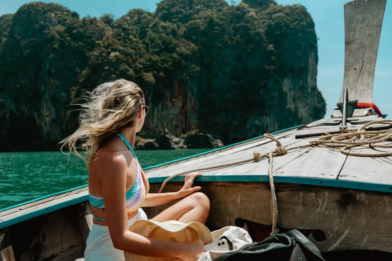 Eine junge Frau sitzt im thailändischen Boot auf dem Weg nach Krabi, Thailand.