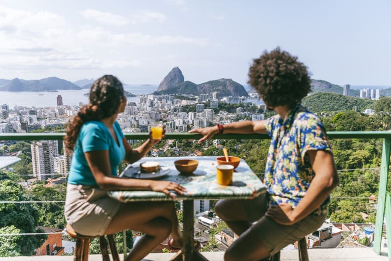 Junges Paar auf einer Terrasse mit Blick auf Rio de Janeiro.