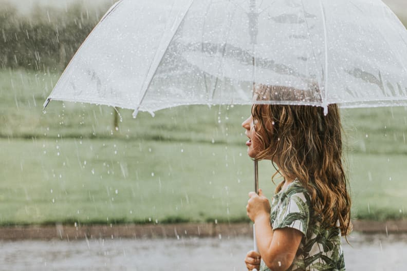 Mädchen hält ein Regenschirm.