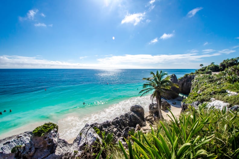 Menschen baden an einem Strand in Mexiko. © AlagnaMarco/Moment via Getty Images