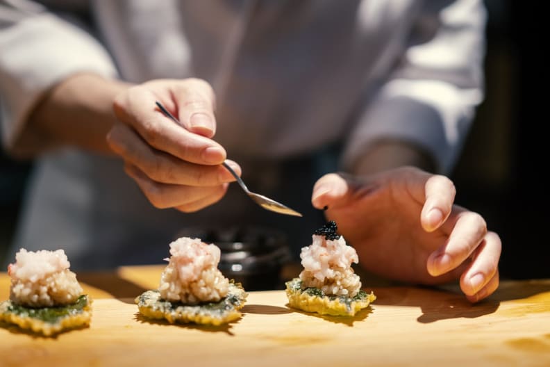 Ein Koch bereitet Sushi zu.