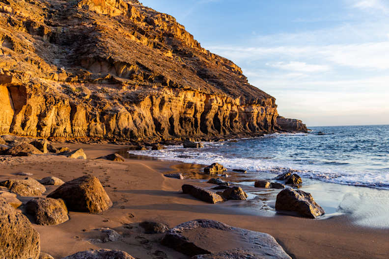 Ein Strand mit Felsen umgeben von Klippen