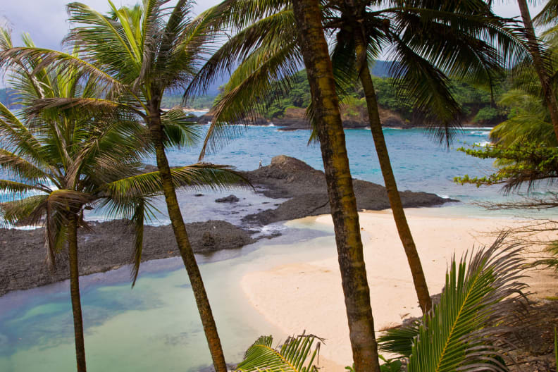 Ein tropischer Strand mit Felsen im Meer auf Sao Tome.