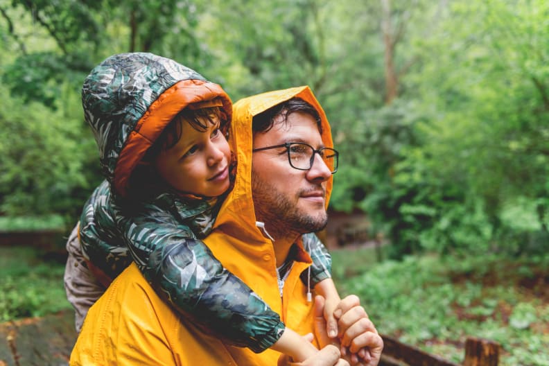Vater und Sohn wandern an einem regnerischem Tag. © StockRocket/iStock / Getty Images Plus via Getty Images