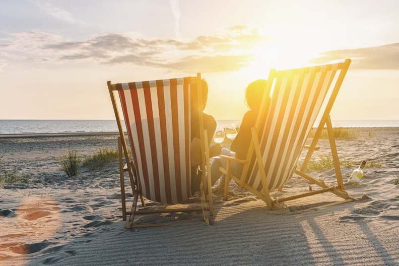 Zwei Personen in Liegestühlen im Sonnenuntergang am Ostseestrand