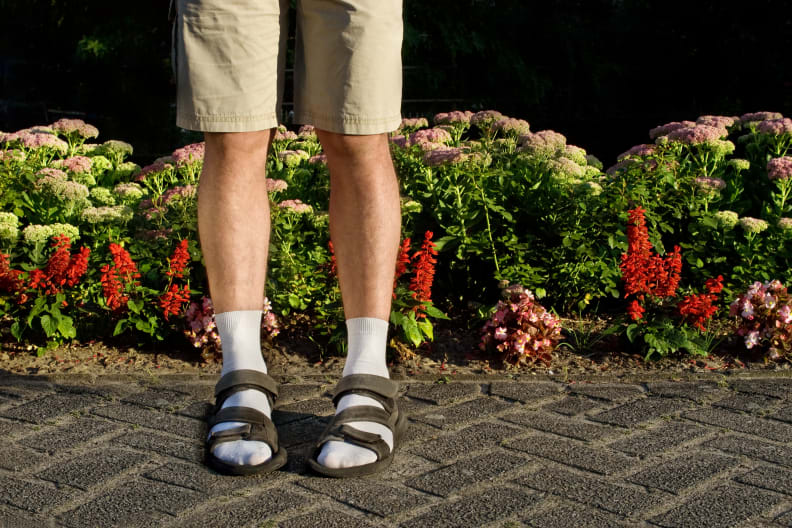 Mann mit weißen Socken in Sandalen im Urlaub.