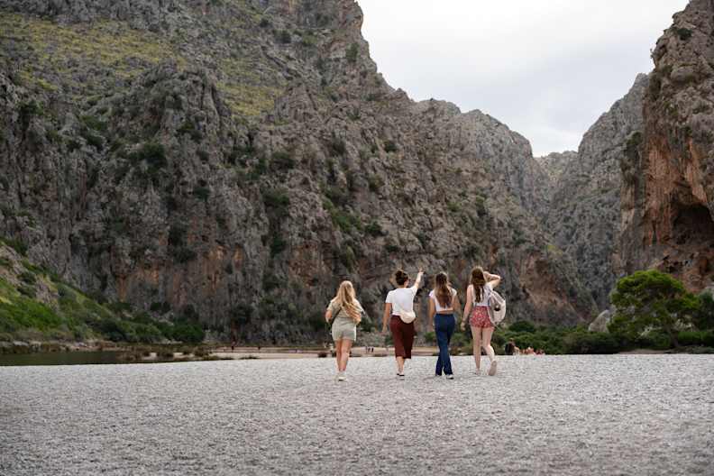 Vier Freundinnen laufen zusammen am Strand