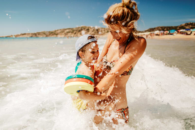 Mutter mit Sohn hat Spaß am Strand