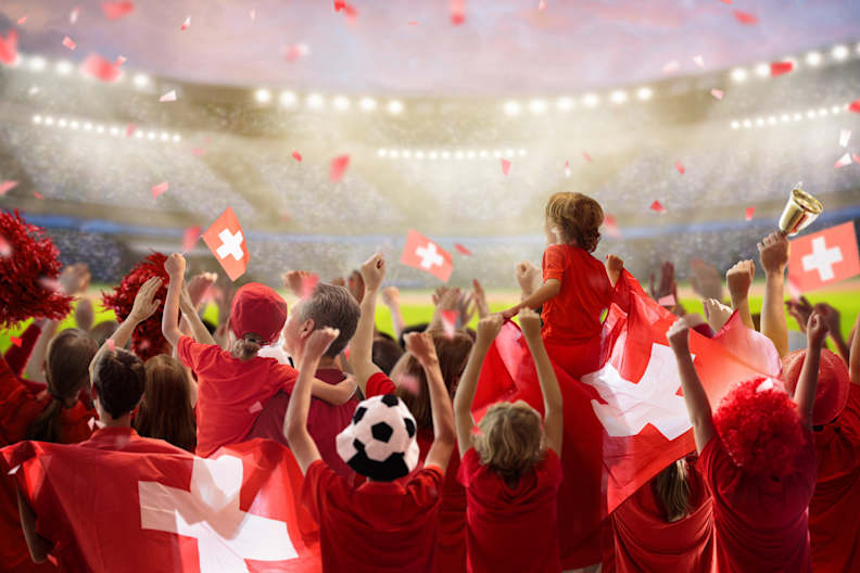 Schweizer Fußball-Fans feiern in einem Stadion © Shutterstock