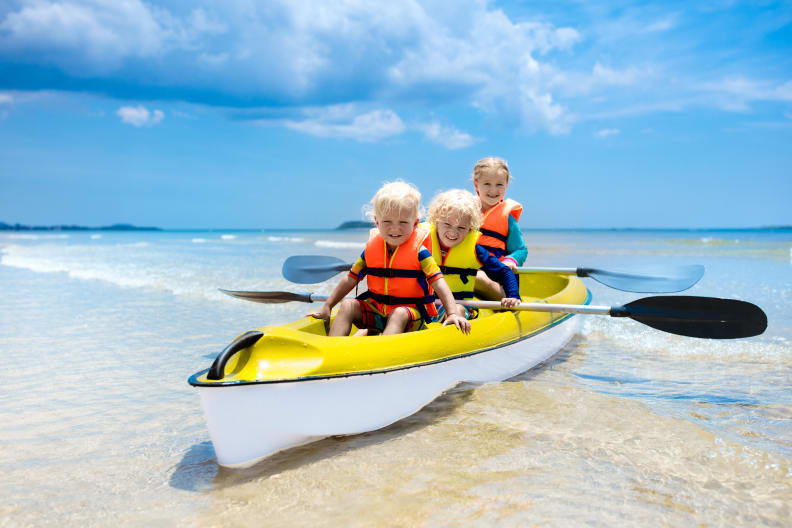 Kinder fahren Kanu im Meer
