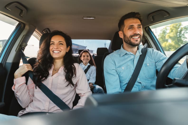 Familie sitzt gut gelaunt im Auto.