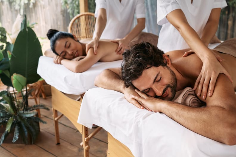 Mann und Frau lassen sich im Wellnessurlaub den Rücken massieren.