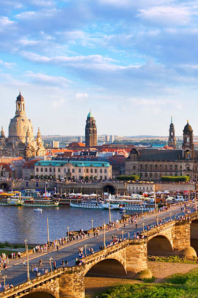 Blick auf eine Brücke und die Altstadt von Dresden mit zahlreichen Türmen und Kuppeln
