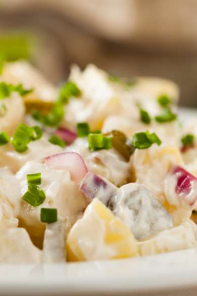 Eine Schüssel voller deutscher Kartoffelsalat mit Mayonnaise.