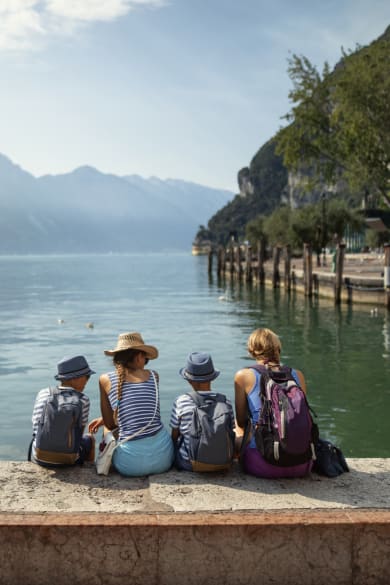 Familie sitzt am Hafen von Riva del Garda und schaut auf den Gardasee © iStock.com/1061876216