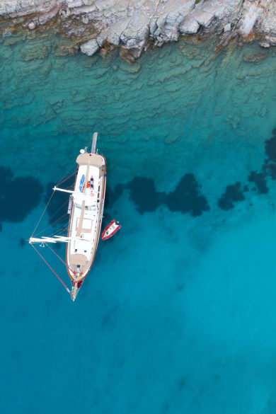 Luftaufnahme von einem Segelschiff in türkisfarbenem Meer © iStock.com/bodrumsurf