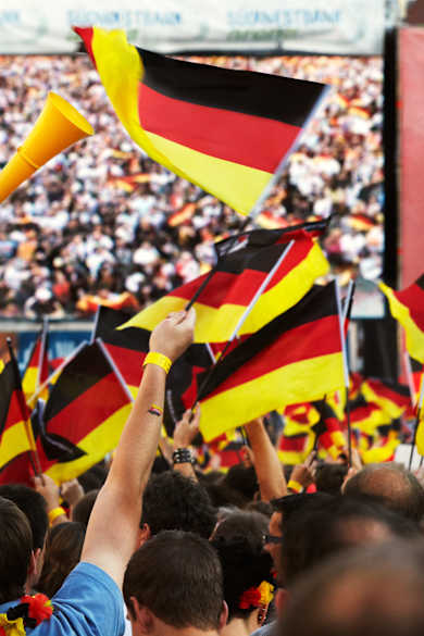 Fans mit Deutschlandflaggen vor einem großen Bildschirm