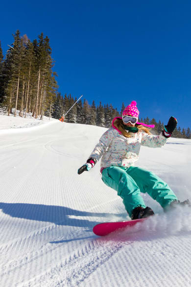 Snowboarderin auf der Piste an einem sonnigen Morgen in den italienischen Alpen © iStock.com/dennisvdw