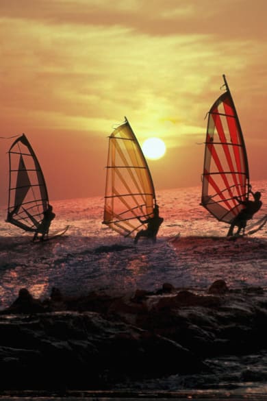 Surfen bei Sonnenuntergang in Terifa, Spanien © iStock.com/ManuelVelasco