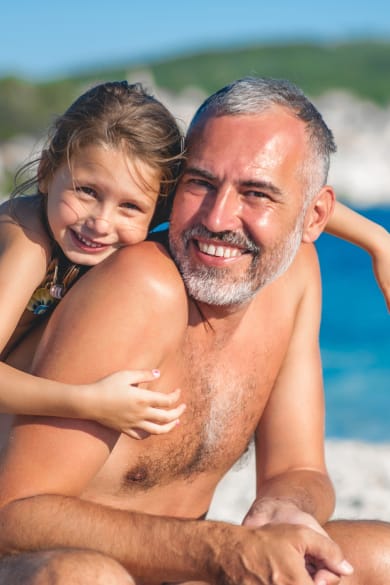 Vater mit seiner Tochter beim Strandurlaub ©CasarsaGuru/iStock