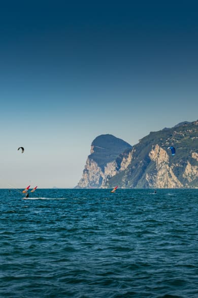 Windsurfer und Kitesurfer am Gardasee in Italien © iStock.com/no_limit_pictures