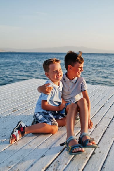 Zwei Brüder sitzen im Türkei Resort am Pier am Mittelmeer ©iStock.com/ASphotowed