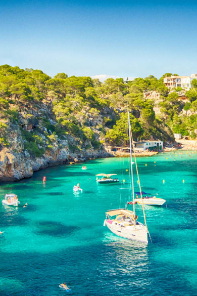 blaues Meer in einer Bucht von Mallorca mit einigen Booten © iStock.com/Josep Bernat Sànchez Moner