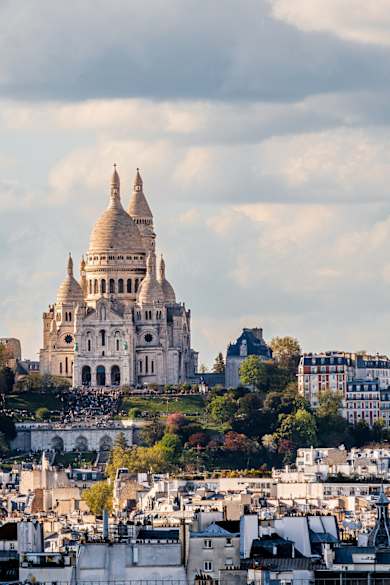 Blick über Häuserdächer in Paris auf Sacré-Cœur.