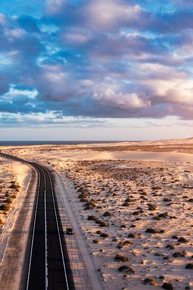 Blick auf die Straße, die durch die Dünenlandschaft bei Corralejo, Fuerteventura, führt