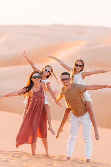 Eine Familie posiert gemeinsam in einer Wüste.