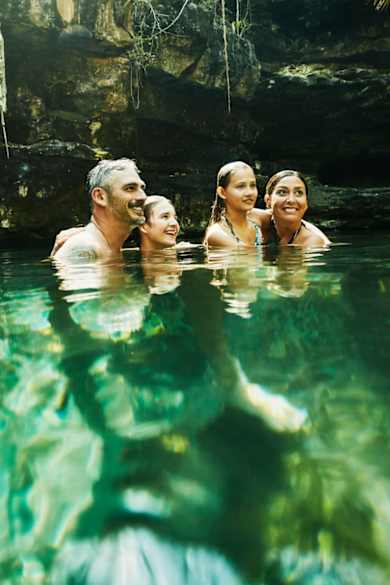 Eine Familie badet in einer Cenote in Mexico.