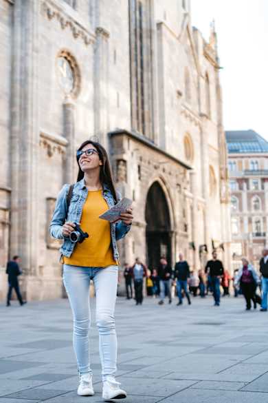 Eine Frau steht mit Stadtplan und Kamera in Wien.